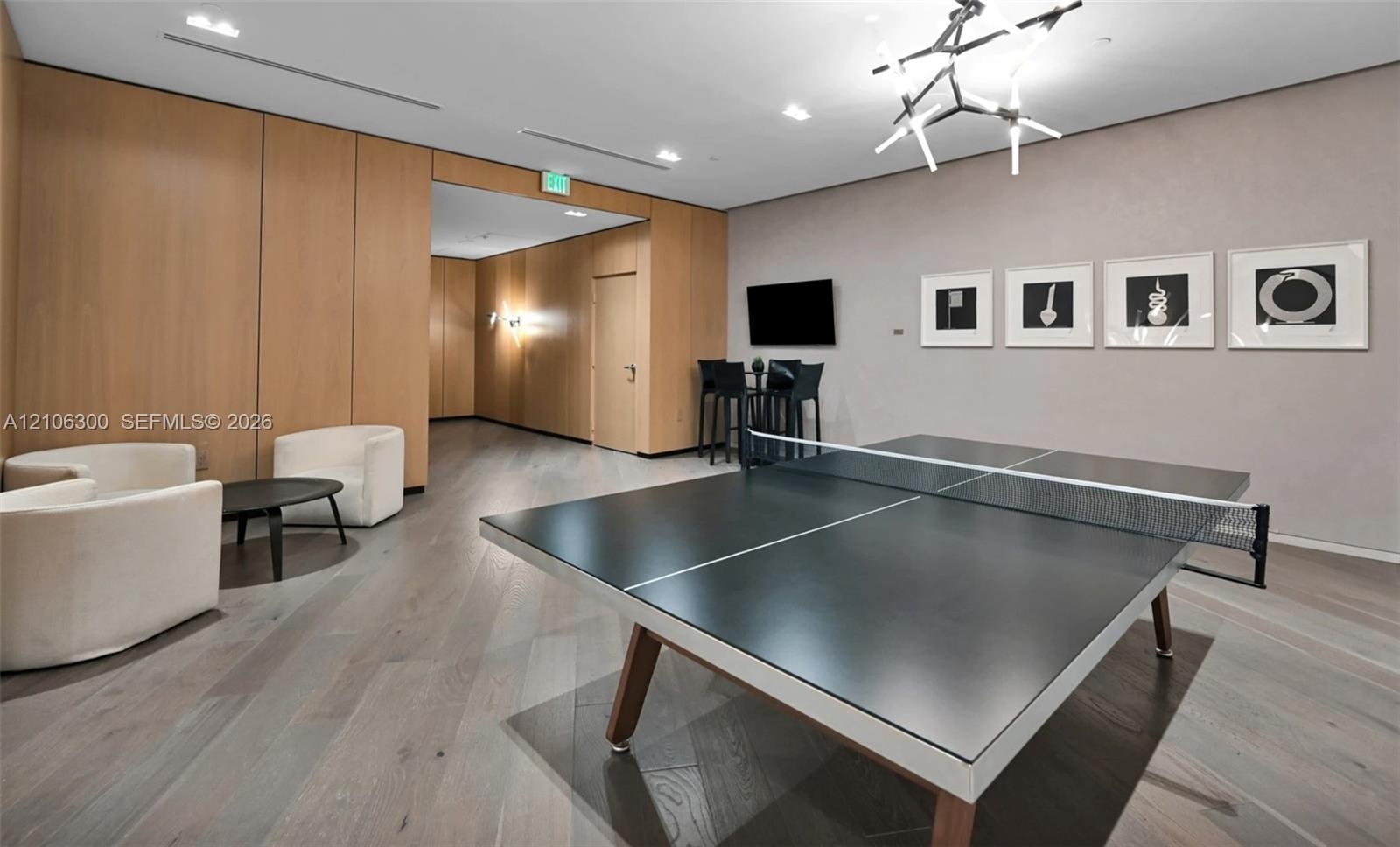 Interior space featuring wood-paneled walls, wood-finish flooring, recessed lighting, and a modern geometric ceiling fixture