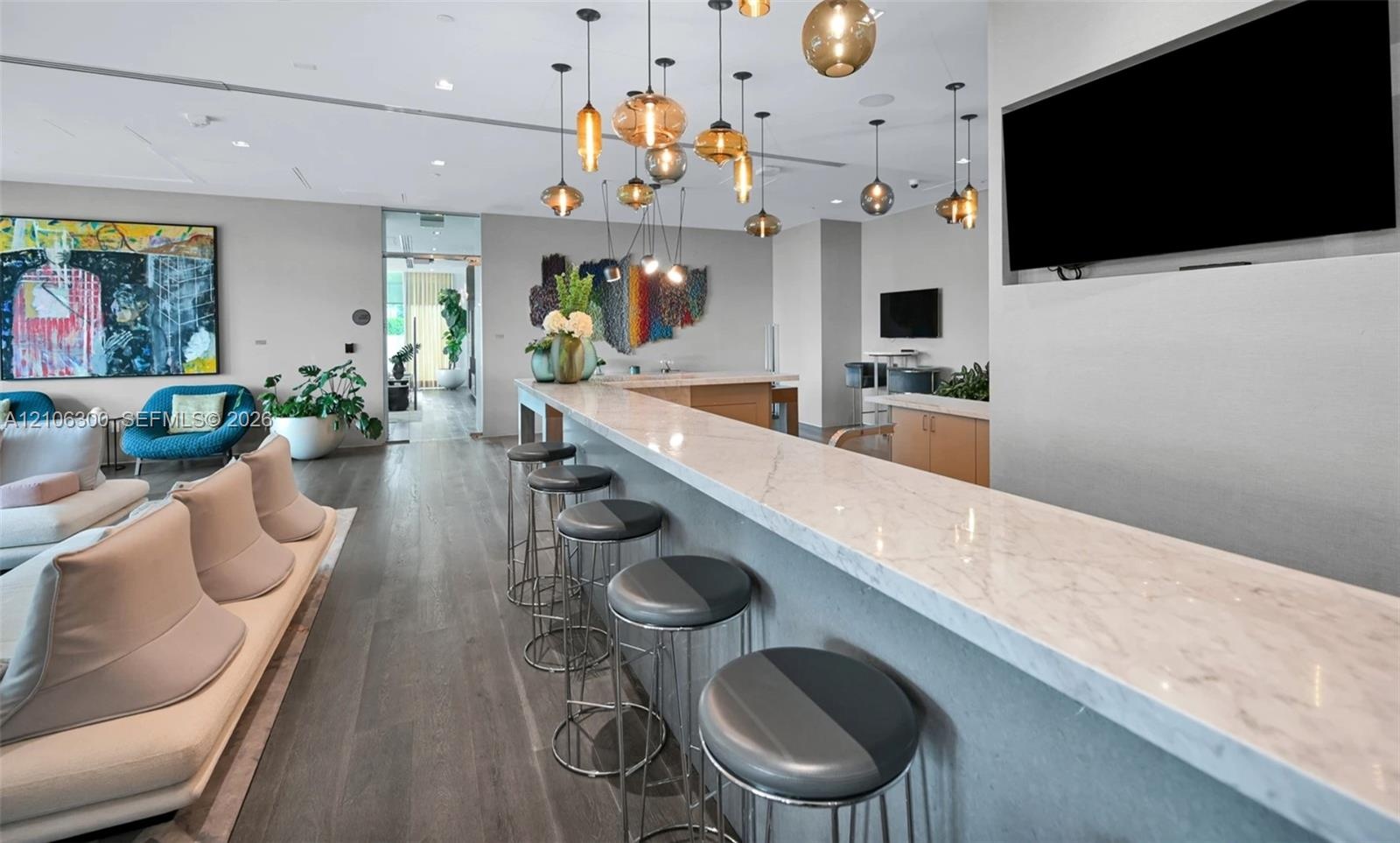 Stone-surfaced bar counter with integrated recessed display wall, wood-finish flooring, and multi-pendant lighting