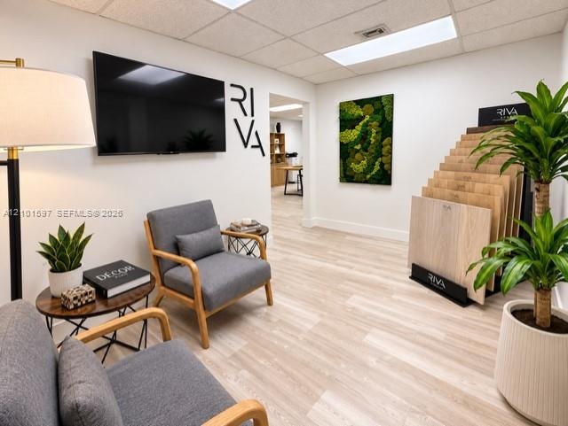 Wood-finish flooring and a suspended tile ceiling featuring recessed lighting