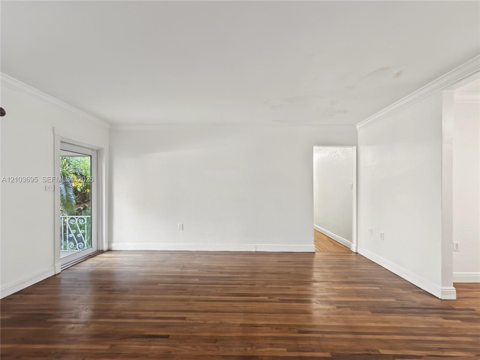 Interior space featuring wood-finish flooring, crown molding, and a full-light glass door