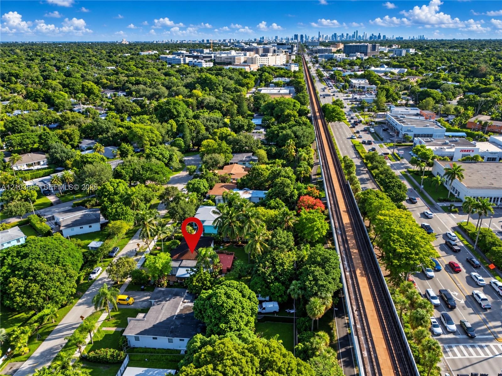 Aerial perspective featuring a residential lot with mature canopy trees, extensive landscaping, and proximity to major thoroughfares and urban skyline