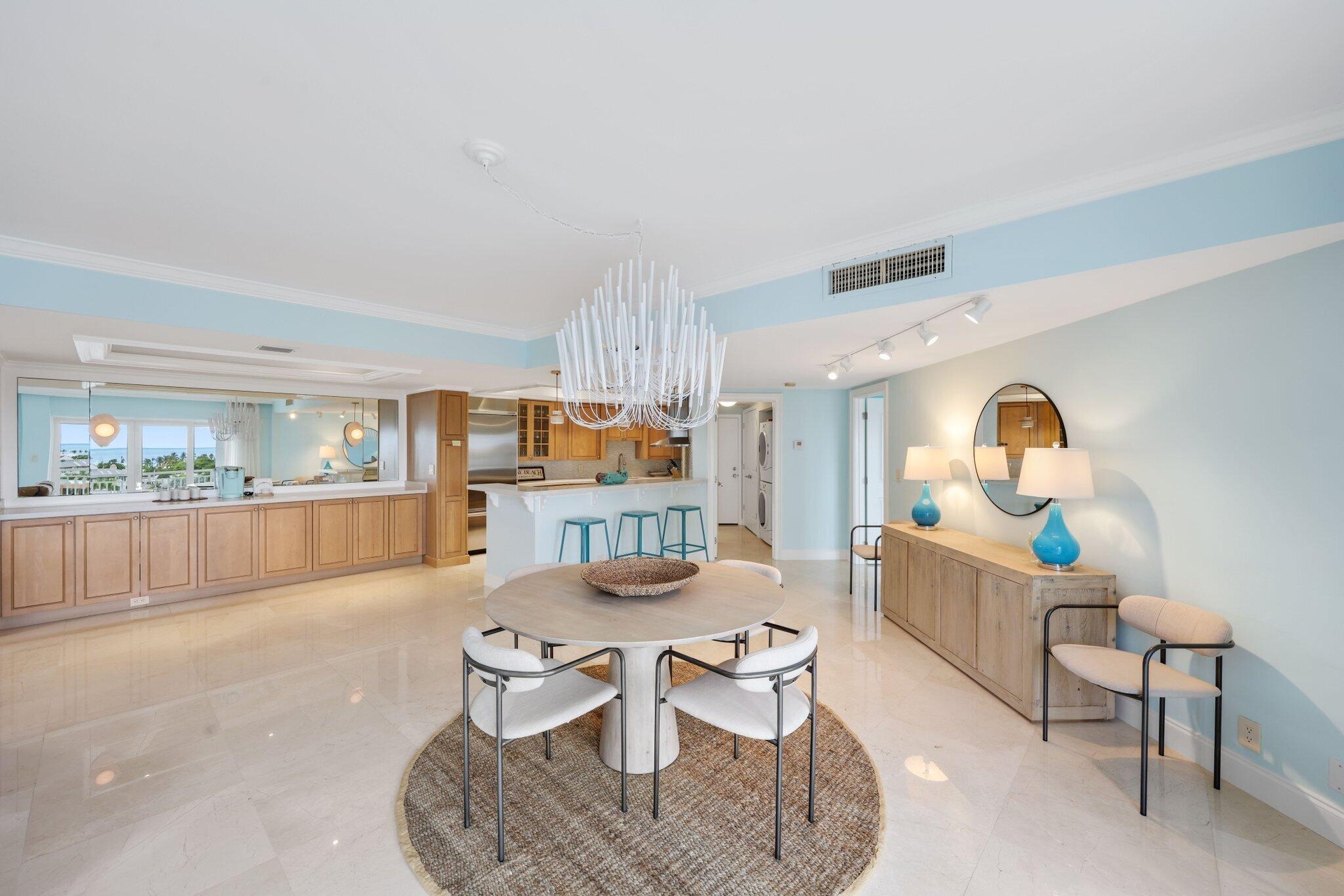 Expansive living and dining area create an impressive sense of openess, while walls of impact glass connect the interiors to the surrounding water and