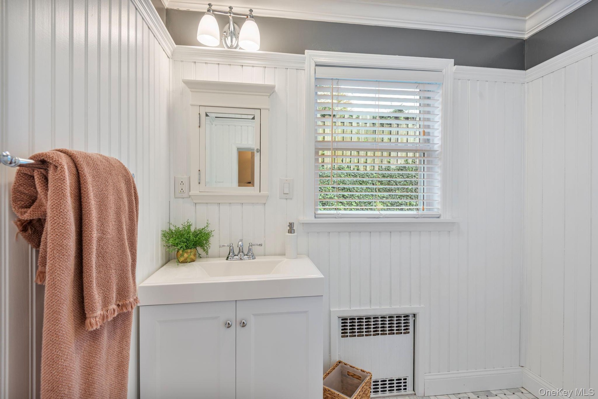 Full bathroom with marble basketweave floors and beadboard paneling on first floor.