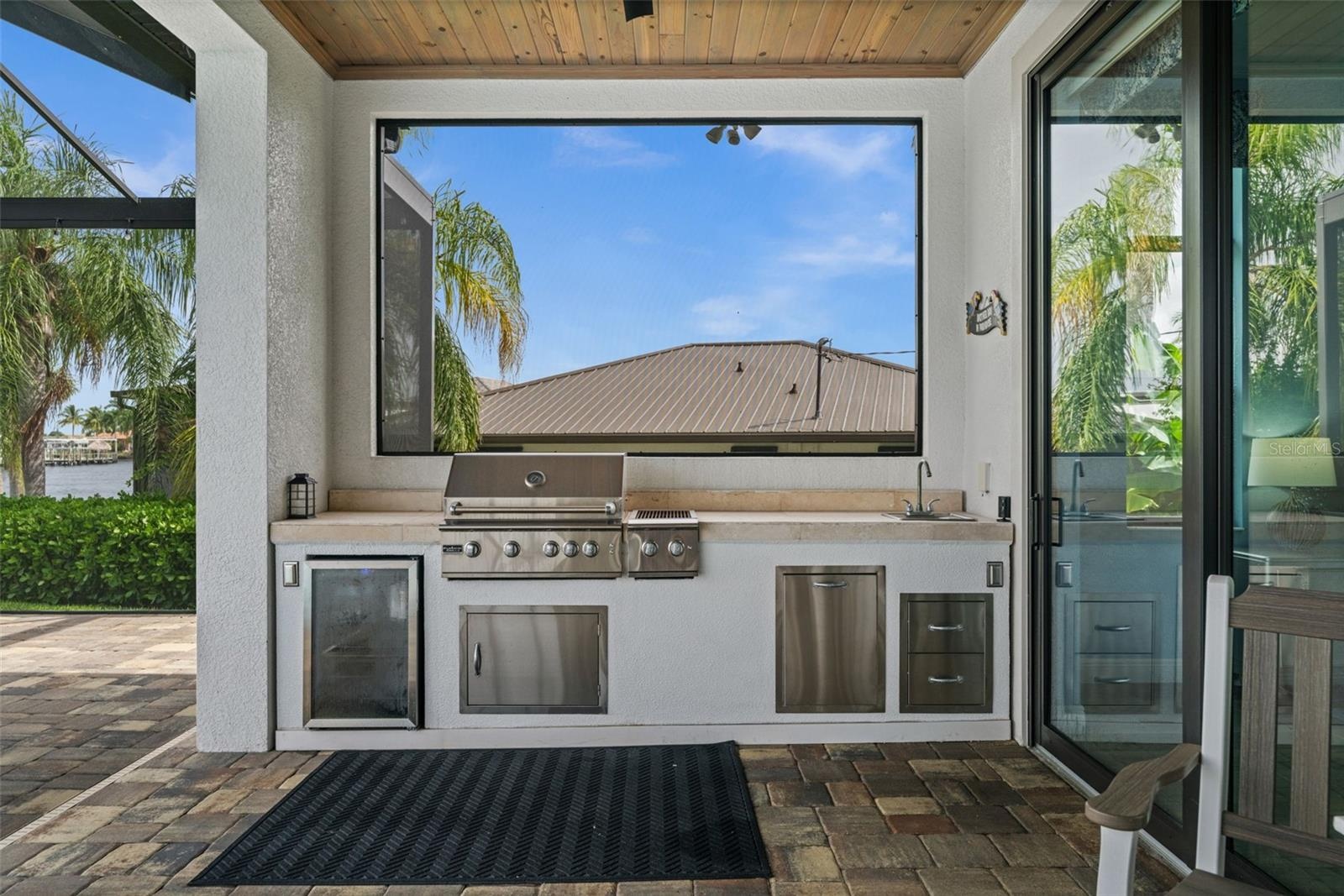 Outdoor kitchen with grill fed by buried propane tank
