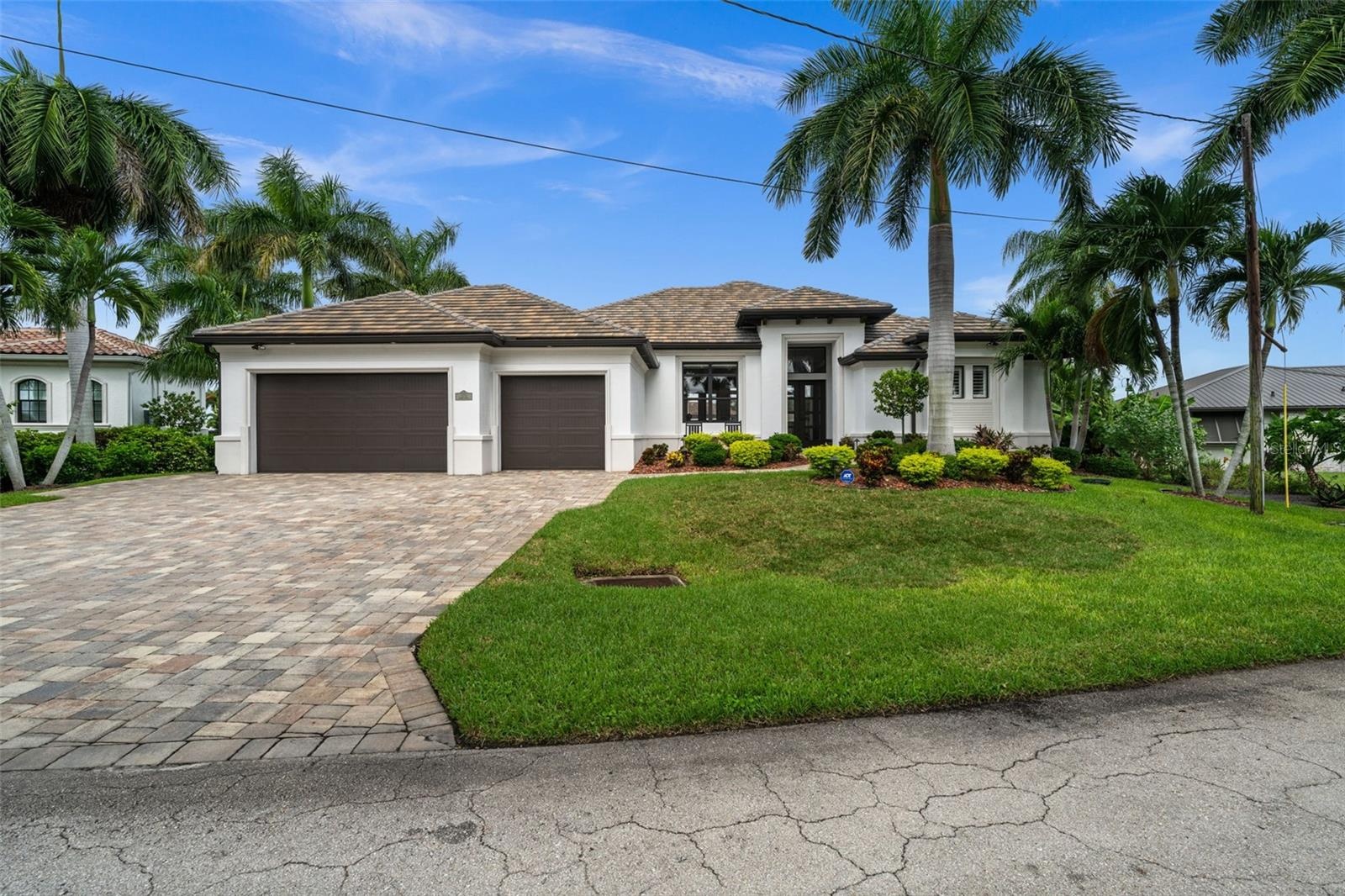 Mature tropical landscaping and tile roof make for a grand entry