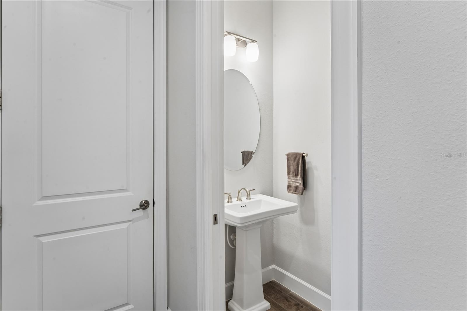 Half bath in hallway leading out to garage