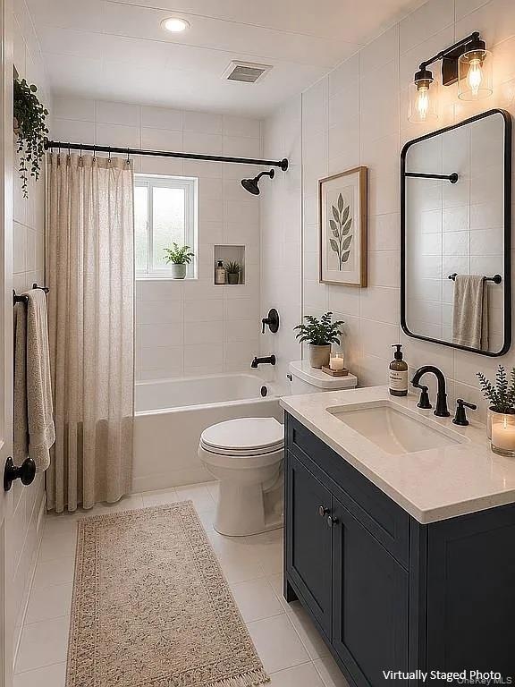 Bathroom featuring a navy vanity cabinet with a light-toned countertop, rectangular wall-mounted mirror with a black frame, recessed wall niche, and m