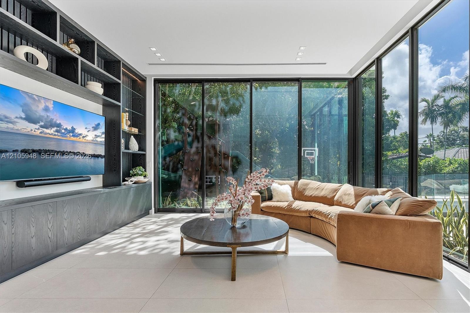 Floor-to-ceiling glass wall, built-in floor-to-ceiling storage cabinetry with open shelving, neutral large-format tile flooring, and recessed ceiling 