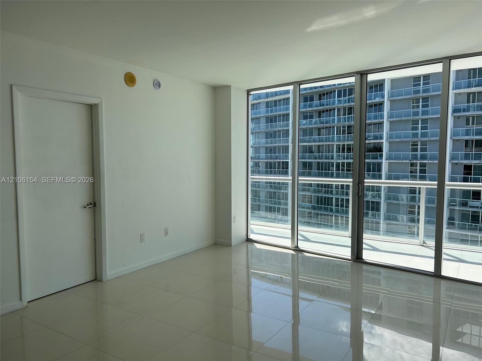 Floor-to-ceiling glass paneling and polished tile flooring