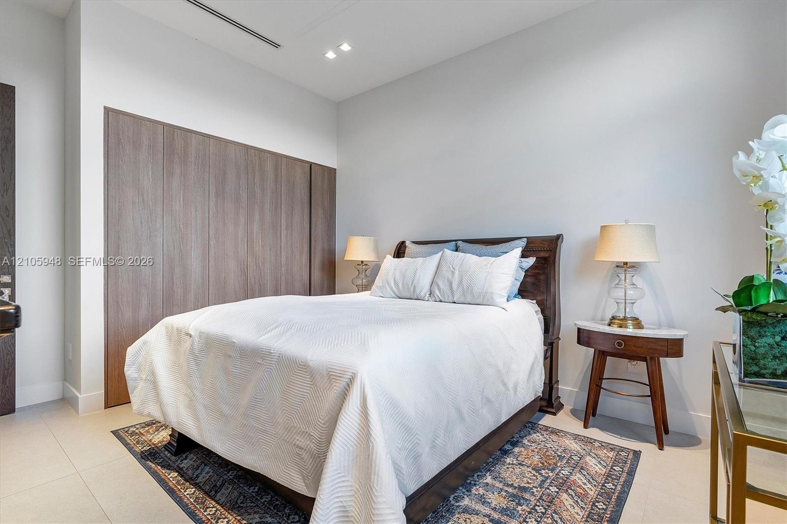 Floor-to-ceiling wood-finish cabinetry, neutral large-format tile flooring, recessed ceiling lighting, and clean-lined interior finishes
