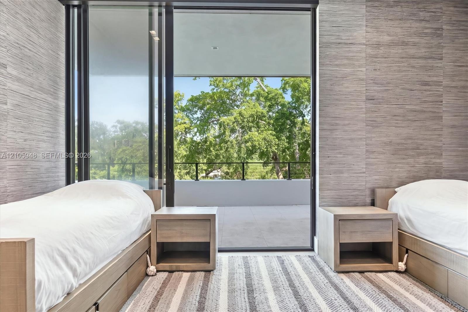 Floor-to-ceiling sliding glass door, private balcony with metal railing, and textured wall coverings