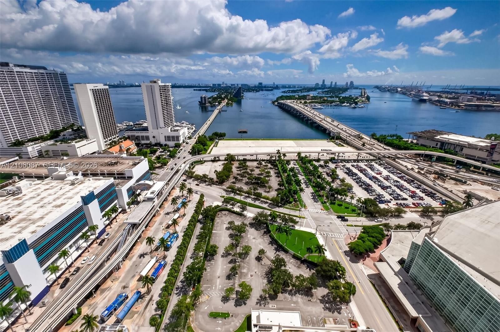 Aerial perspective showcasing high-density urban infrastructure, expansive waterfront proximity, multi-lane causeway systems, and integrated public tr