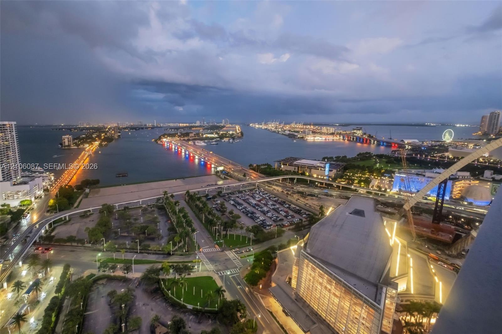 High-altitude perspective featuring expansive water frontage, illuminated bridges, urban infrastructure, and coastal skyline scenery