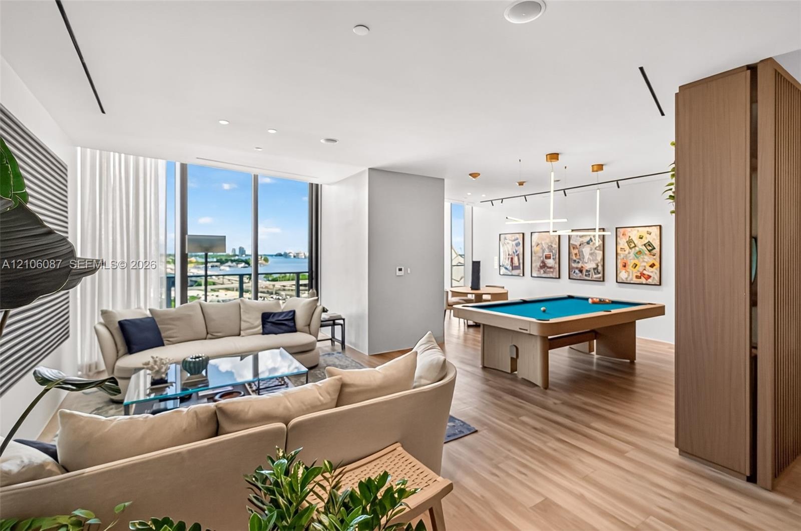 Open-concept interior featuring floor-to-ceiling windows, wood-finish flooring, recessed lighting, and custom built-in cabinetry