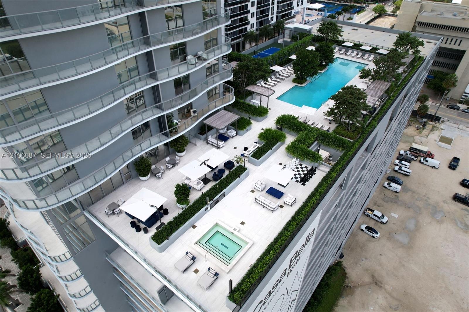 Expansive rooftop terrace featuring a rectangular swimming pool, integrated spa, built-in landscaping planters, and tile flooring