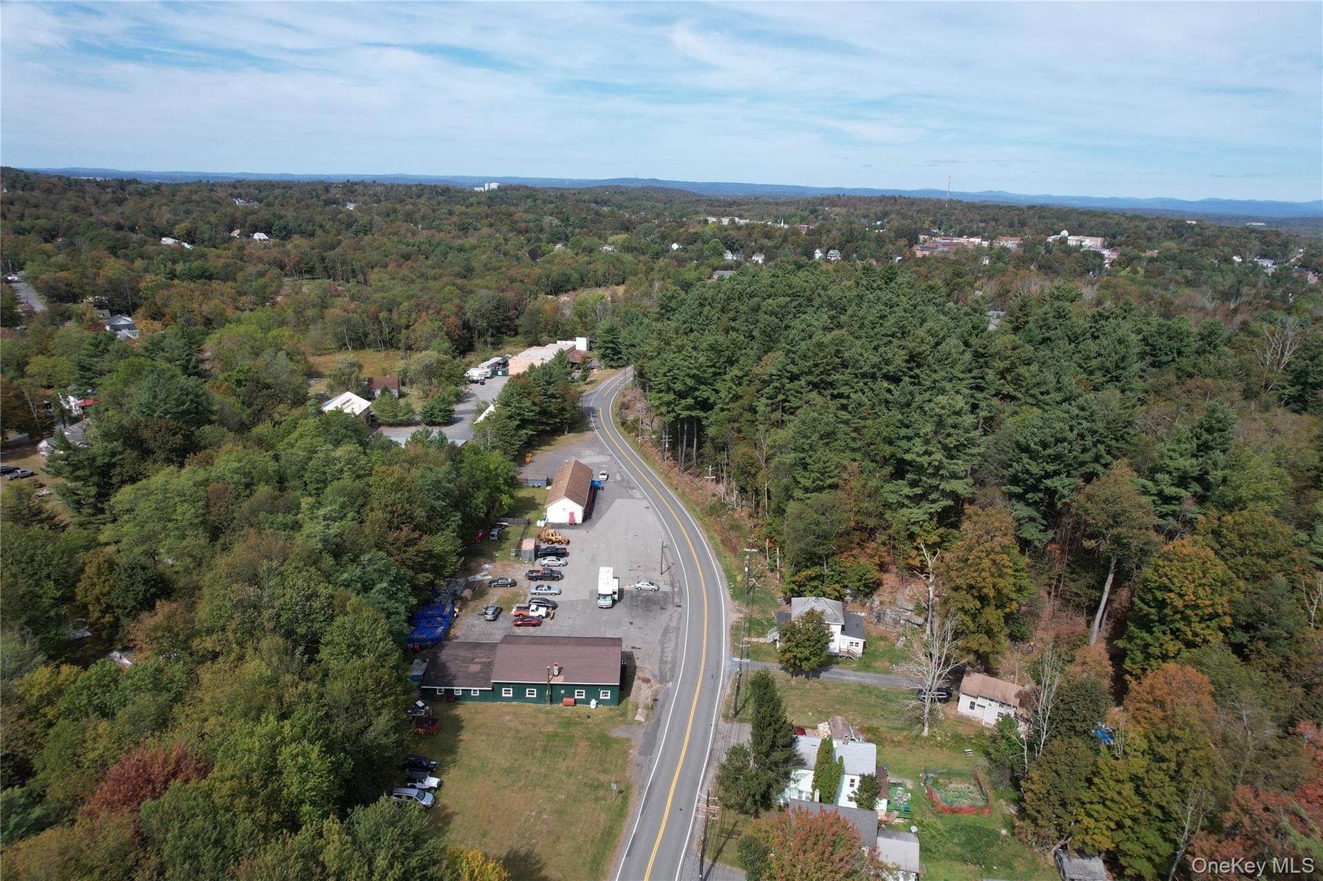 Aerial view of property and surrounding area featuring a forest