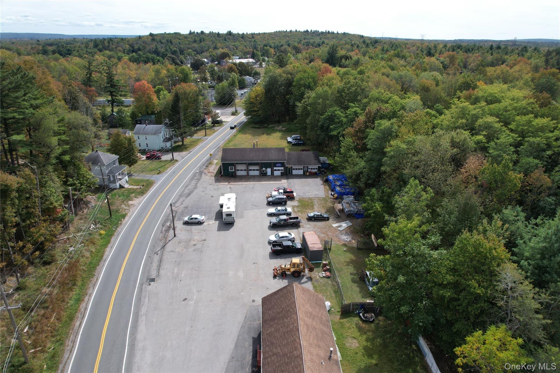 Aerial view of property and surrounding area featuring a heavily wooded area