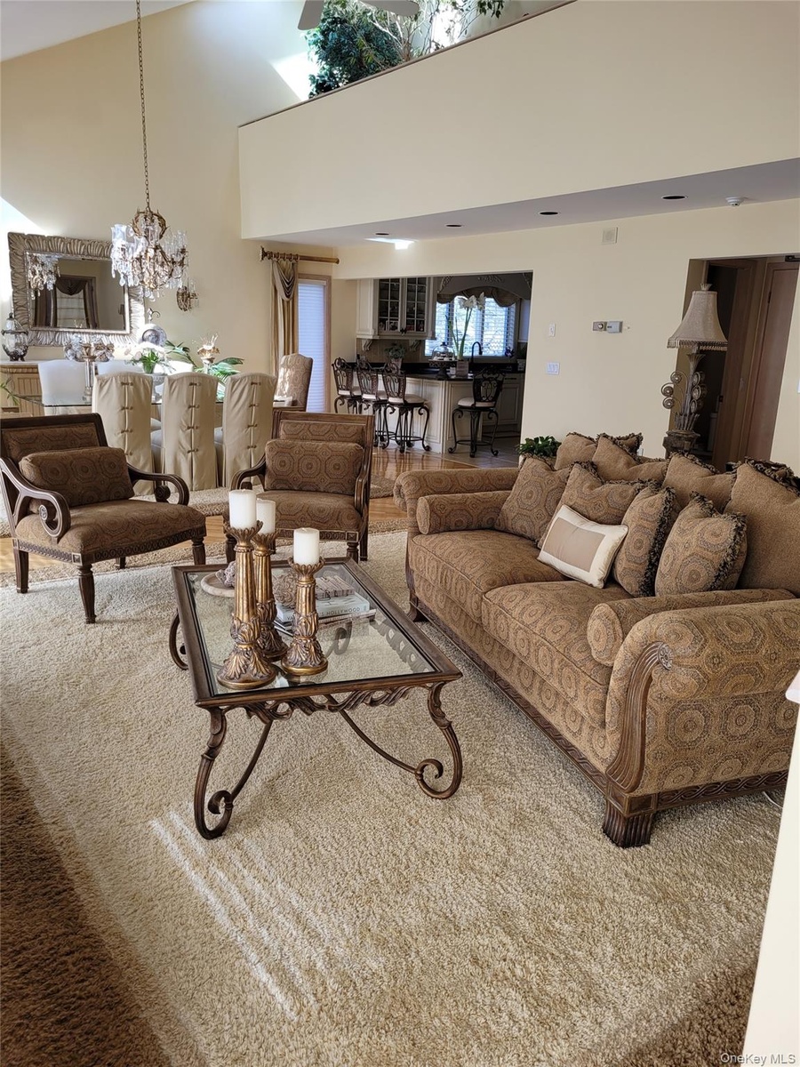 High ceilings with an upper-level balcony, a formal dining area, and a kitchen with a breakfast bar