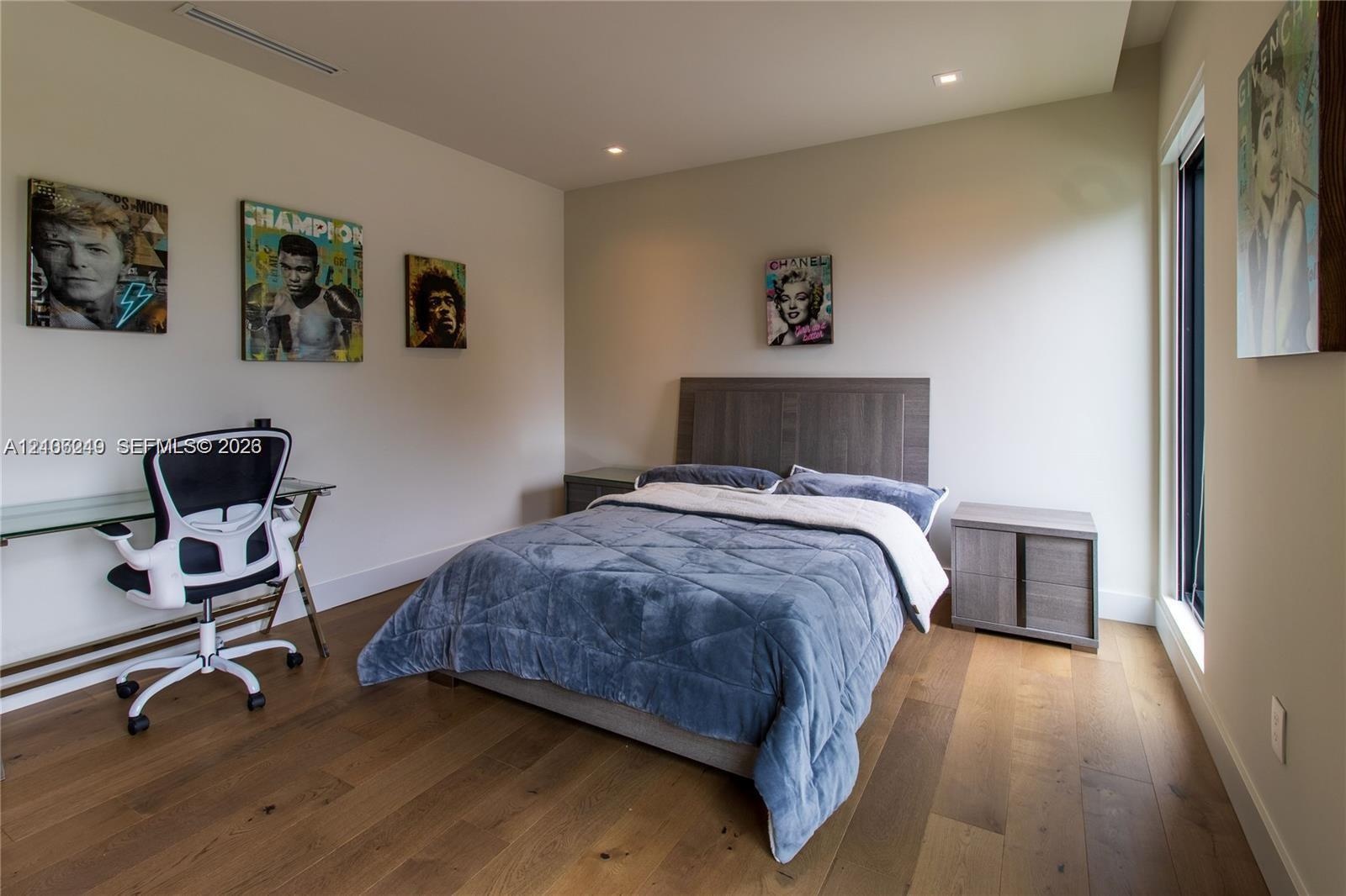 Wood-finish flooring, recessed lighting, and expansive floor-to-ceiling windows