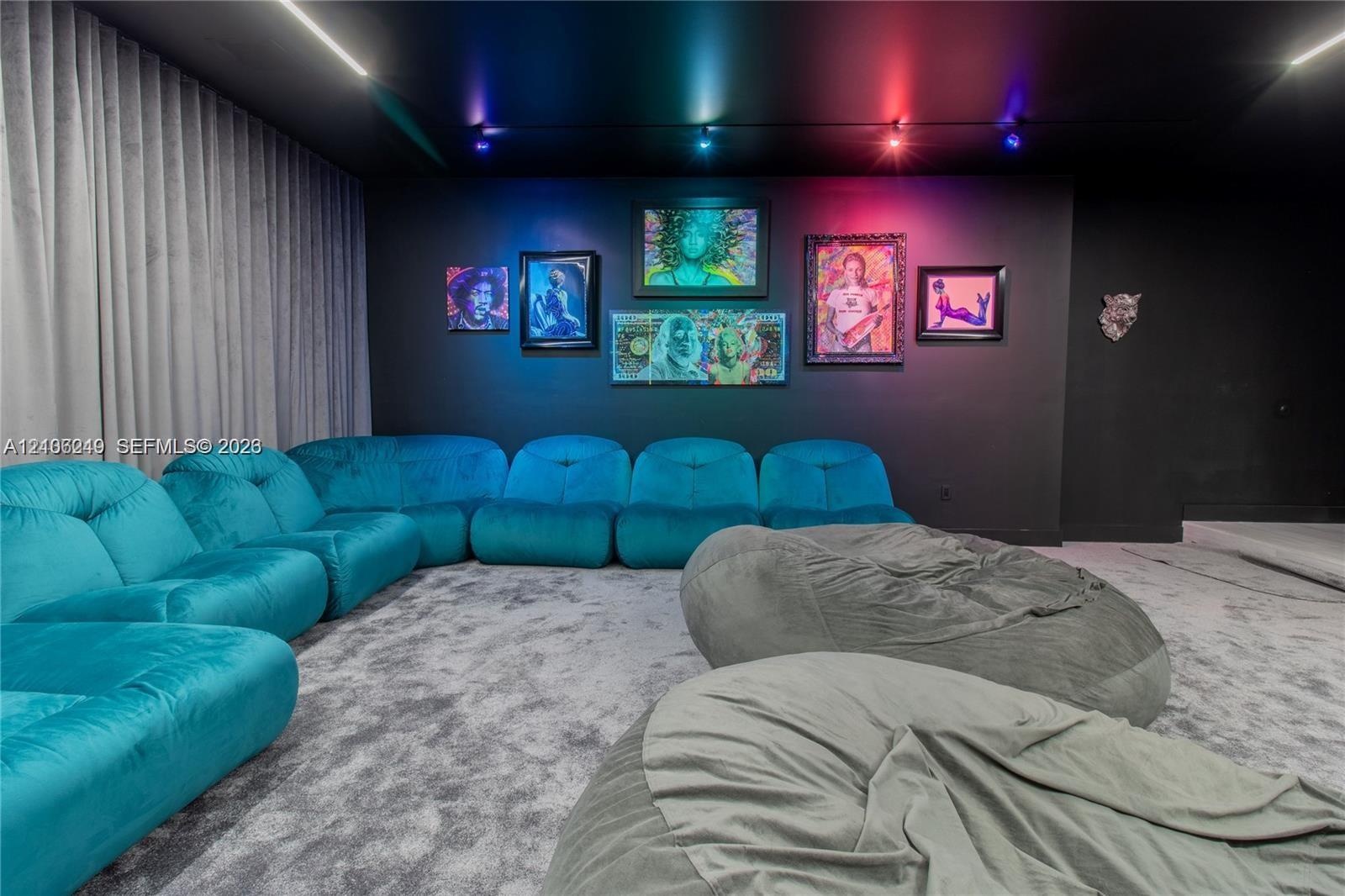 Media room featuring a matte black ceiling and accent wall, integrated track lighting, and full-height floor-to-ceiling drapery