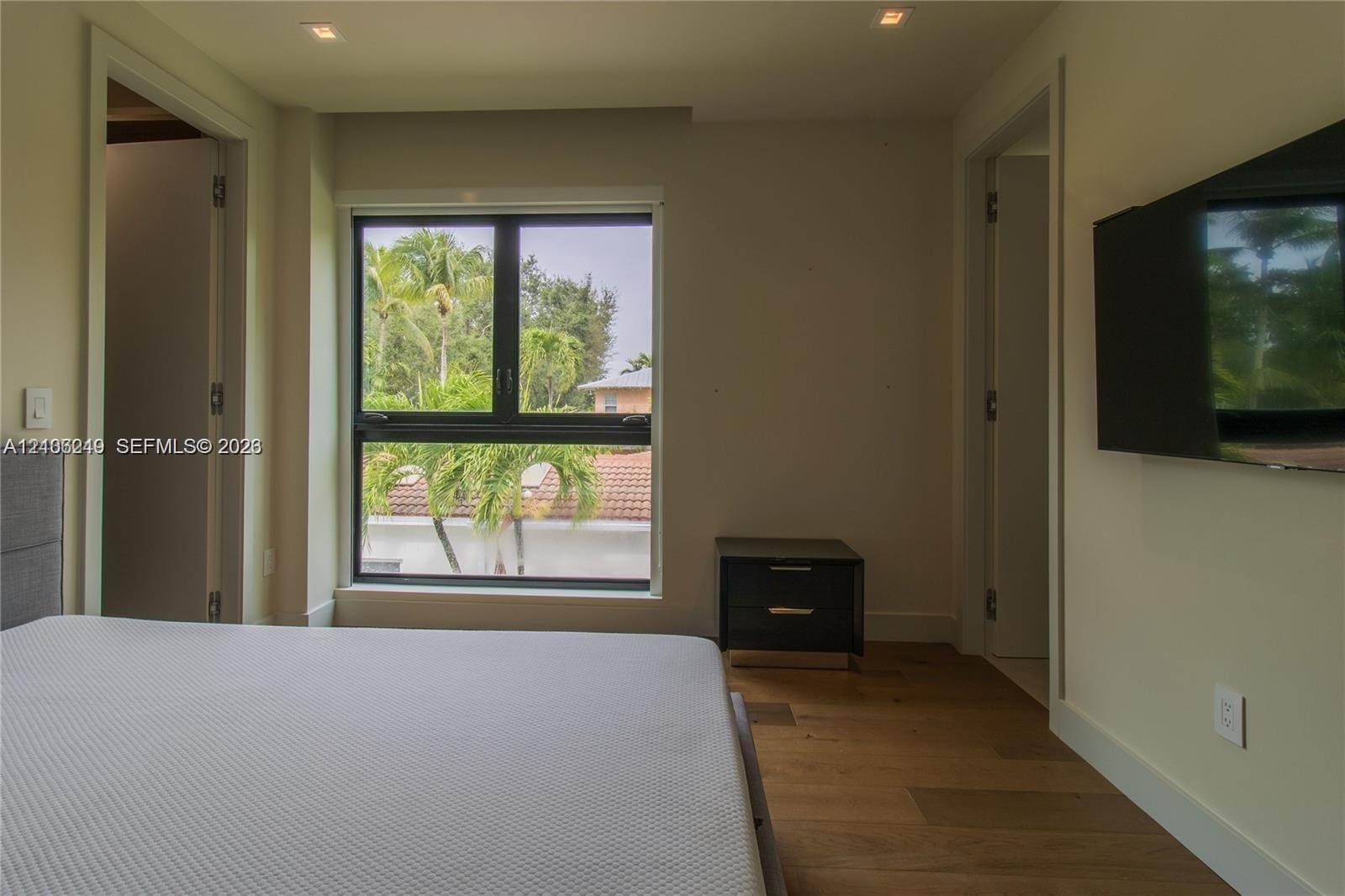 Room featuring recessed lighting, dark wood-finish flooring, a large dual-pane window, and two doorways