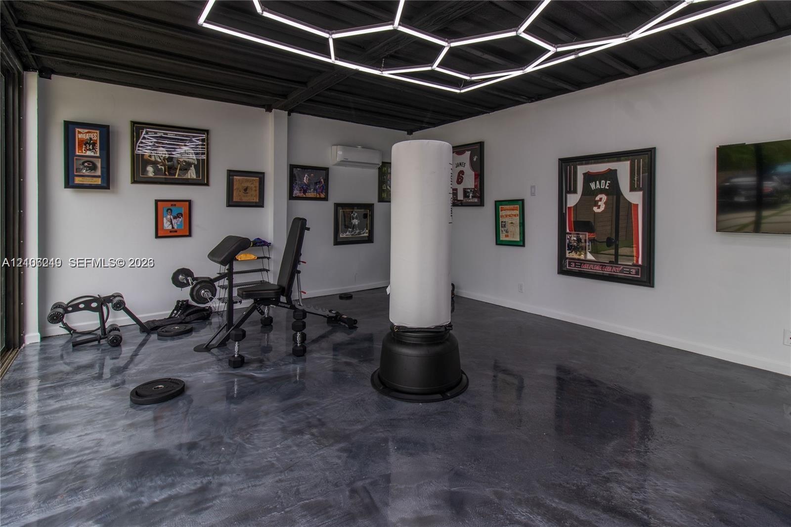 Polished concrete flooring, exposed ceiling beams, geometric LED overhead lighting, and wall-mounted climate control unit