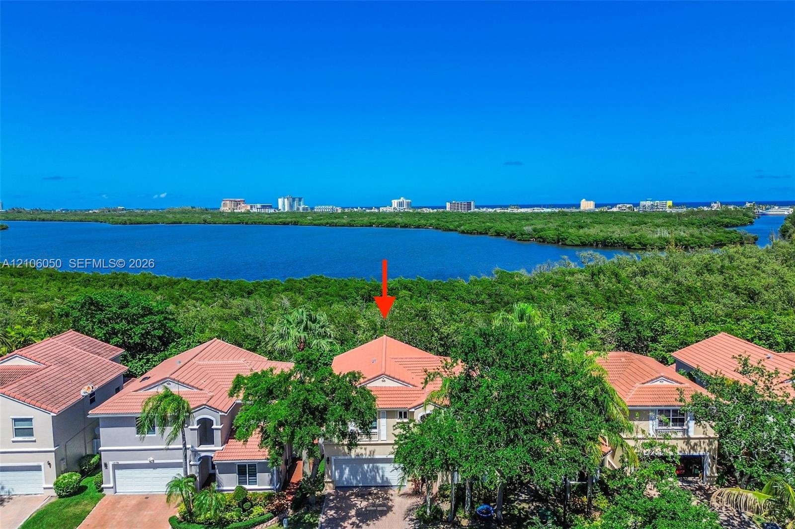Aerial perspective showcasing this waterfront residence nestled within a lush, mature landscape