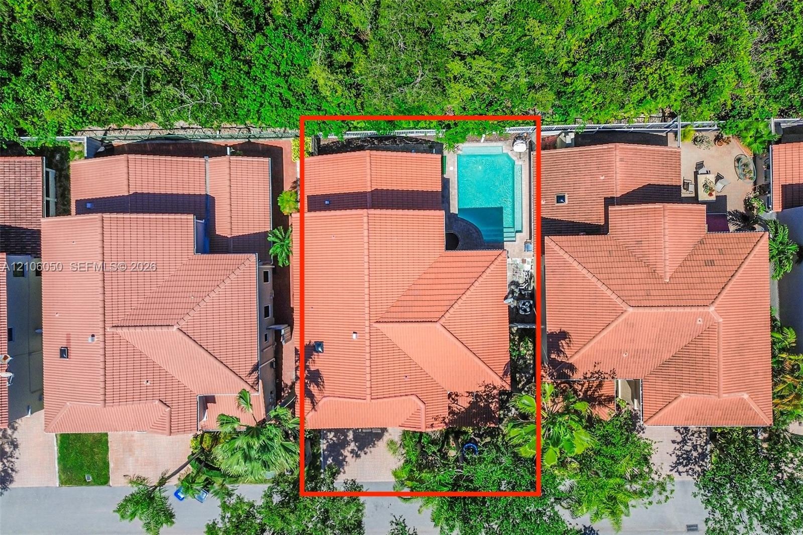 Aerial perspective of a multi-level residence featuring a clay tile roof and a private, in-ground swimming pool
