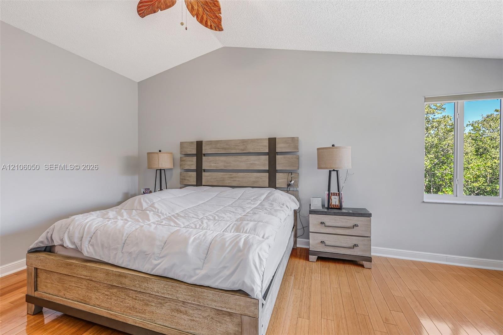 Vaulted ceilings, wood-finish flooring, and natural light from a single-pane window